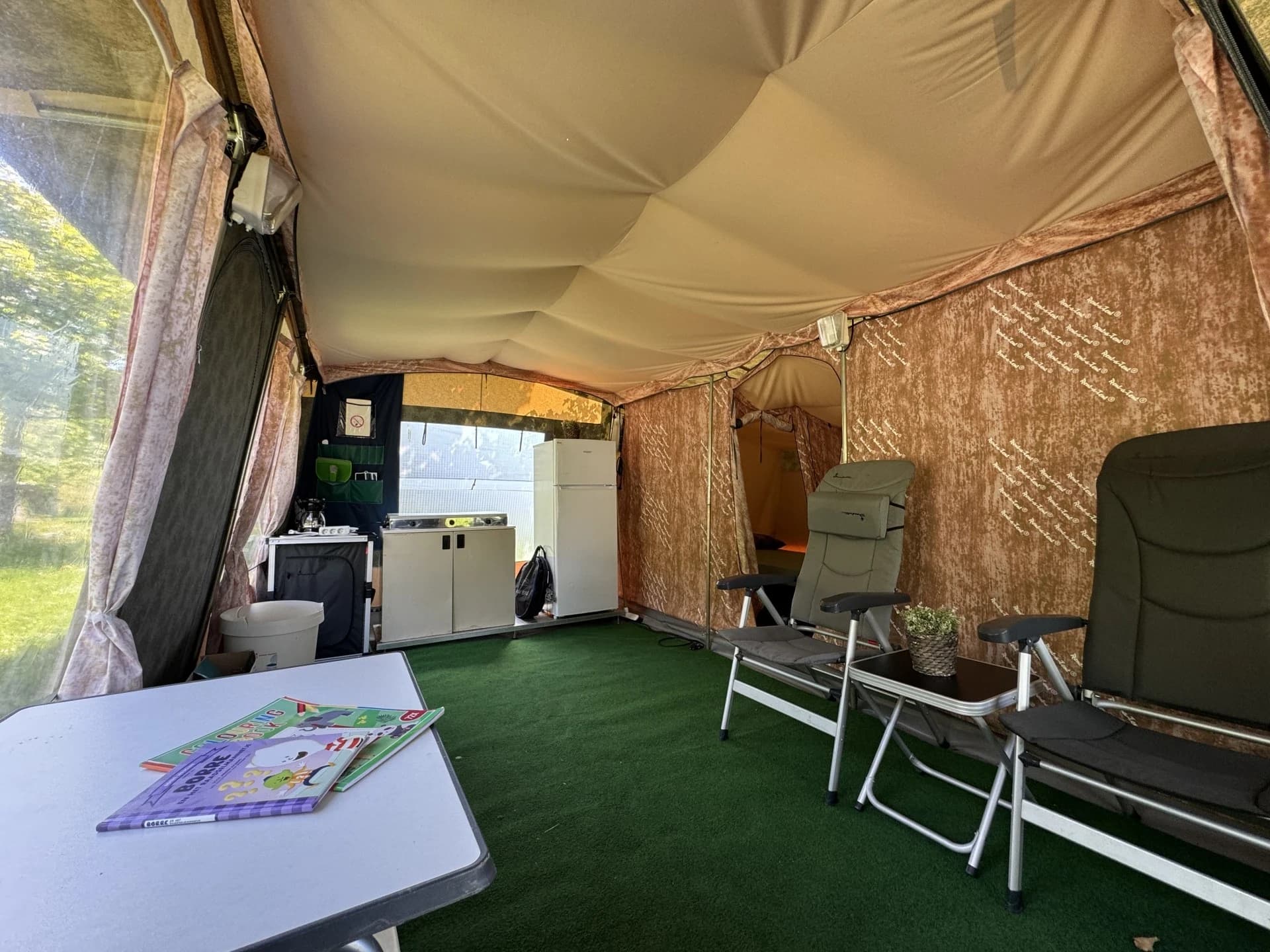 Leefruimte met relaxstoelen, keukenblok en frigo